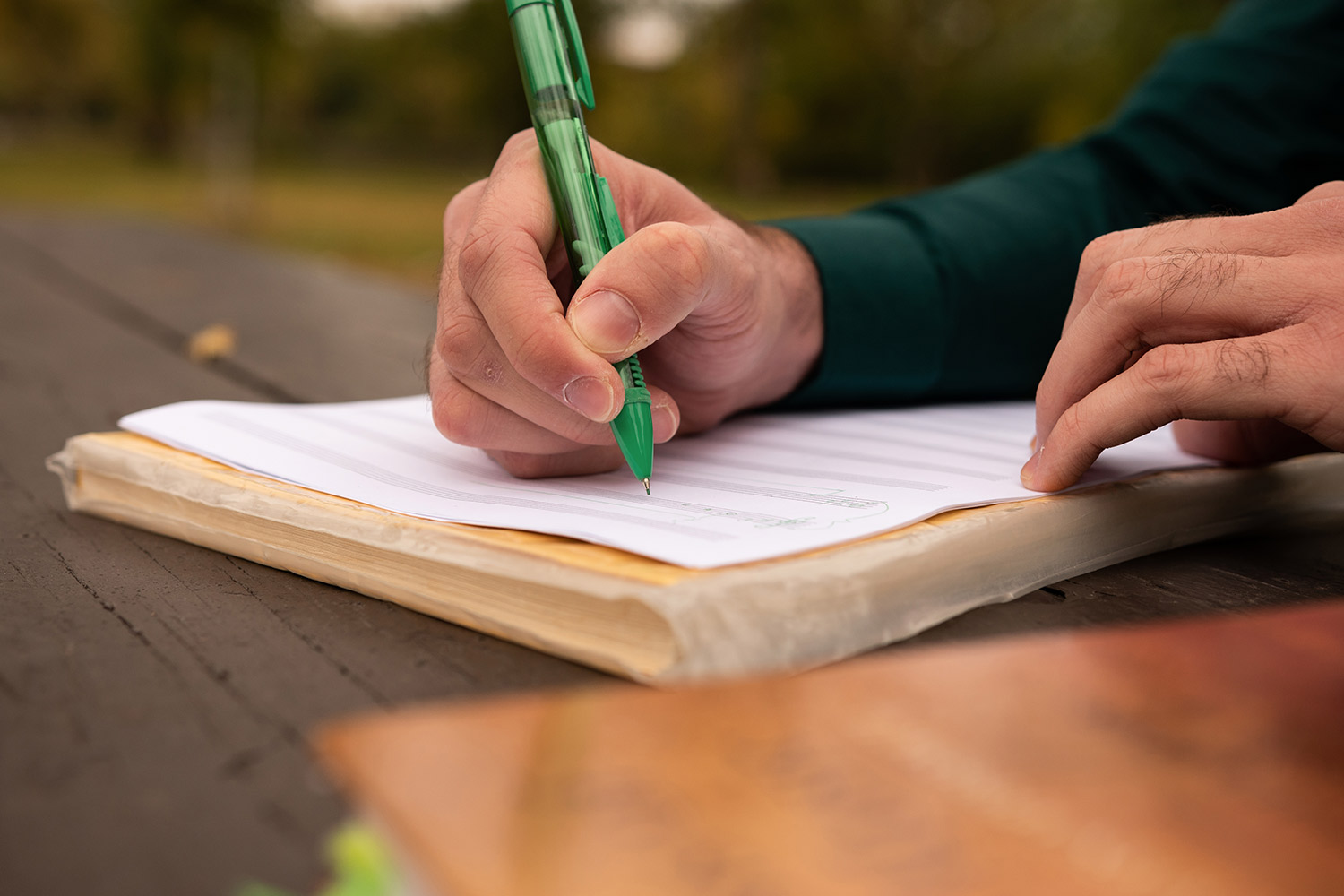 Julian Jenson writing on a music staff paper to prepare for music theory tutoring.